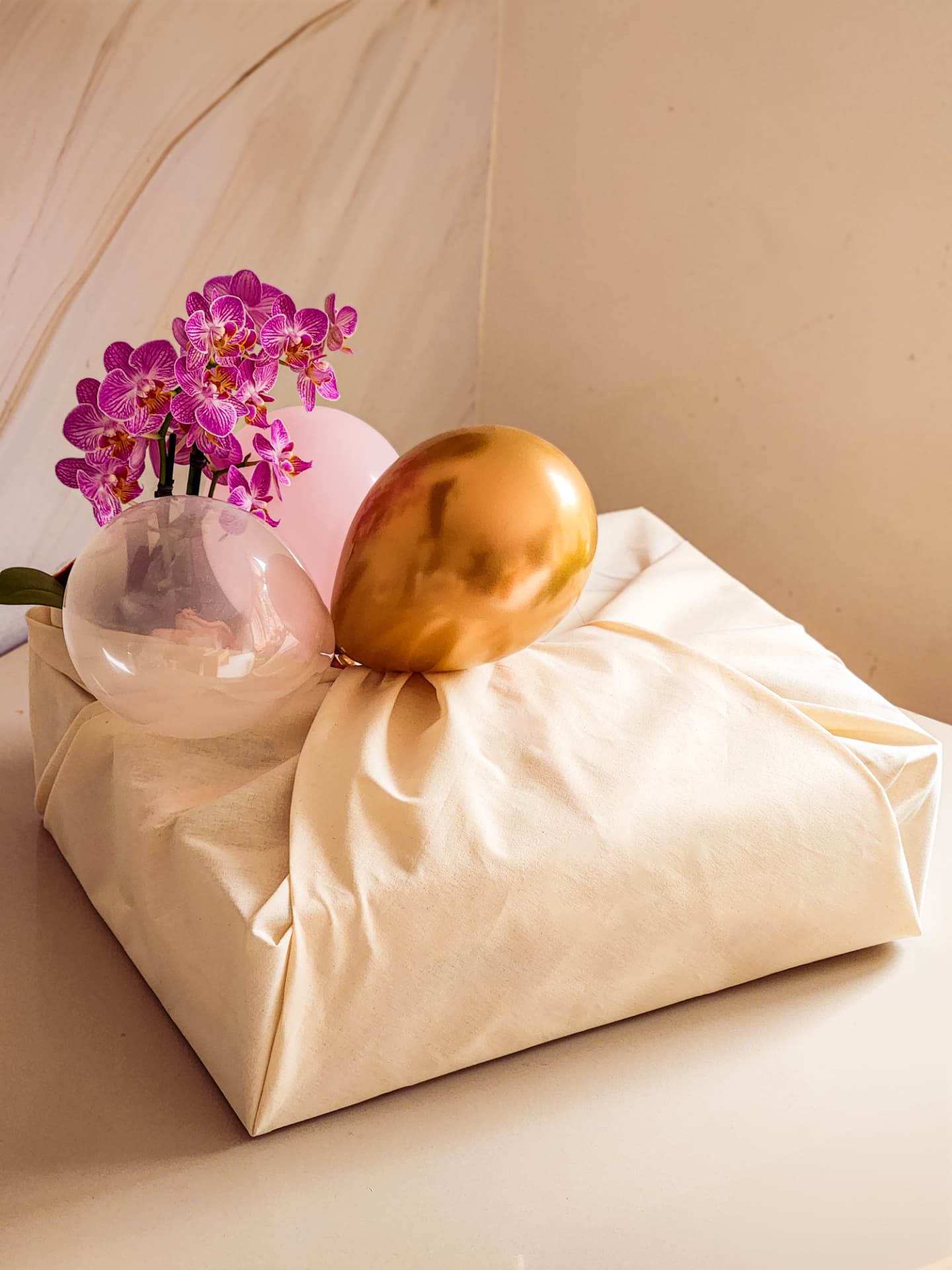 Cesta embalada em algodão cru com orquídeas e bexigas