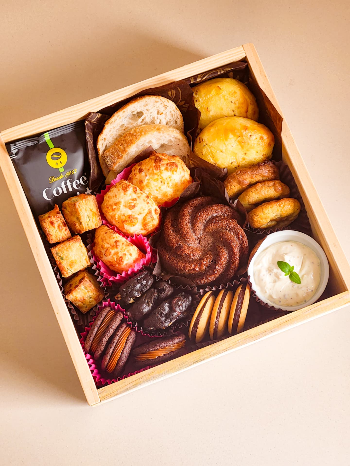 Cesta Deli da manhã aberta com pães, bolo de chocolate, cookies, biscoitos e creme de mostardas